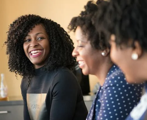 Three professional women smiling and laughing together